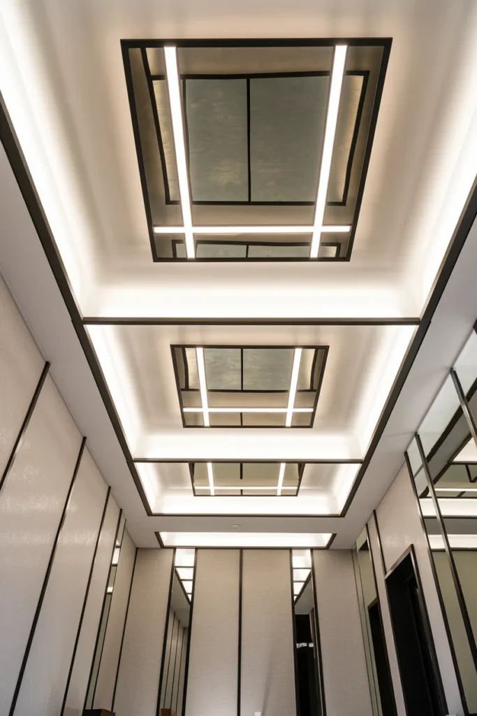 30 False Ceiling Ideas That Instantly Make Your Home Look More Luxurious 12 Mirror Panel False Ceiling with Linear LED Design